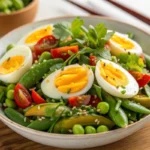 Bowl of vibrant Edamame and Egg Salad recipe. A healthy and colorful side dish, featuring green soybeans and classic egg salad with a touch of herbs